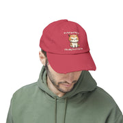 Ironically Inked red distressed cotton twill cap featuring a grumpy orange kitten graphic and cheeky text on a man.
